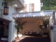 an outdoor patio with chairs and potted plants on the steps leading up to it