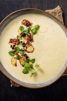 a bowl filled with soup and garnish on top of a table