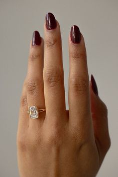 a woman's hand with a ring on it and a diamond in the middle