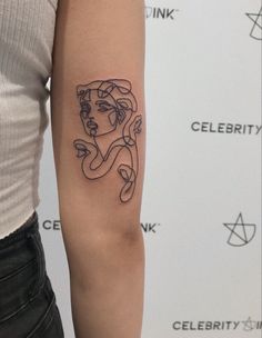 a woman's arm with a tattoo on it that has an image of a woman