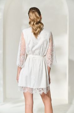 Made in a unique delicate white french lace design, the Lara Lace Robe is the perfect gift for the bride-to-be on her wedding day. Featuring scalloped lace edges along the neckline, hem and sleeve cuffs, this robe exudes old-world elegance. The body of the Lara Robe is fully lined to provide our brides the coverage they need. A slip dress is not required for under this robe, but if you're in search of one we recommend our White Bridal Slip Dress. Material: French lace with a fully lined bodySlee Lace Dress With Lace Cuffs For Wedding Night, Feminine Scalloped Lace For Wedding, Feminine White Scalloped Lace, Long Sleeve Lace Wedding Dress With Lace Cuffs, White Scalloped Lace Dress For Wedding Night, White Lace Dress With Lace Bodice For Ceremonies, Elegant Lace Trim Dress For Ceremony, Feminine Lace Dress With Lace Bodice For Weddings, Feminine Lace Bodice Dress For Wedding