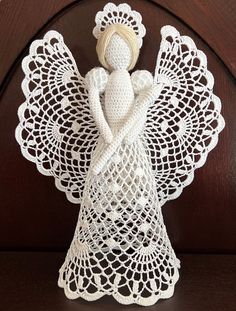 a crocheted angel figurine sitting on top of a table