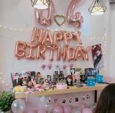 a birthday party with balloons, photos and pictures on the wall in front of it