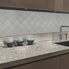 a kitchen counter with bowls on it and a faucet in the middle next to them