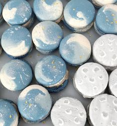 blue and white macaroons with yellow sprinkles are shown in this image