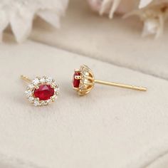 These 18K Yellow Gold Oval Ruby Stud Earrings with a Lab Diamond Halo are the perfect addition to any jewelry collection. Luxury Oval Ruby Earrings, Elegant Red Oval Diamond Earrings, Elegant Gold Cluster Halo Earrings, Luxury 14k Gold Oval Earrings, Luxury Oval Cluster Earrings For Anniversary, Elegant Oval Cluster Earrings For Anniversary, Fine Jewelry Halo Cluster Earrings As Gift, Fine Jewelry Cluster Earrings With Halo For Gift, Exquisite Yellow Gold Earrings With Halo Design