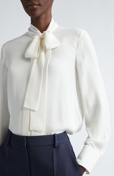 An off-center bow lends tasteful asymmetry to a ivory-hued top fashioned in Italy from fluid silk. 27" length (size 40 IT) Hidden-button placket; ties at neck Band collar Long sleeves 100% silk Dry clean Made in Italy Designer Clothing Timeless Silk Blouse For Formal Occasions, Semi-formal Feminine Silk Blouse, Formal Silk Tie-neck Blouse, Formal Silk Tie Neck Blouse, Elegant Semi-formal Tie Neck Blouse, Fitted White Blouse With Bow, Silk Tie Neck Blouse For Formal Occasions, Elegant Tie Neck Blouse For Daywear, Elegant Tie Neck Blouse For Semi-formal Occasions