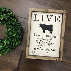 a sign that says live like someone left the gate open next to a fake wreath