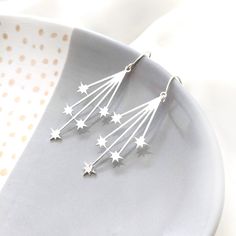 "A statement pair of sparkly silver drop earrings of falling stars. These unique earrings design can upgrade any outfit and will add that extra sparkle to your day or night. Free Shipping Size: Total length: approx. 5.5cm- 2.2\" inch Element is approx. 4.2 x 1.9 cm- 1.6 x 0.7\"inch The earrings is handmade silver over brass. **Ear hook is made of 925 silver * Nickel free - - - - - - - - - - - - - - - - - - - - - - - - - - - - - - - - - - - - - - - - - - - - - - - - - - - - - - ♥ Item will arrive Stars Earrings, Christmas Jewellery, Silver Star Earrings, Wolf Jewelry, Falling Stars, Earrings Design, Turtle Necklace, Earrings Christmas, Statement Drop Earrings