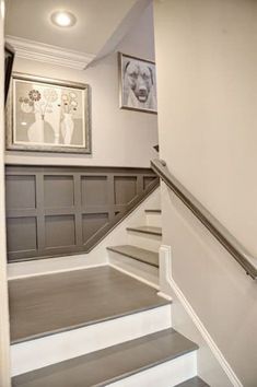 there is a staircase leading up to the second floor with pictures on the wall above it