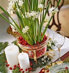 a table topped with candles and flowers on top of a table