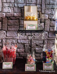 there are candy bars and candies on the table in front of a brick wall