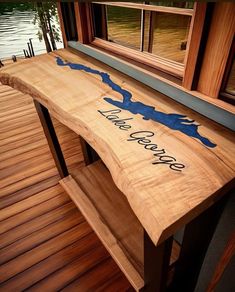 a wooden bench sitting on top of a wooden floor next to a window with the words lake george written on it