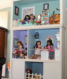 the doll house is full of dolls and toys, including children's bookshelves