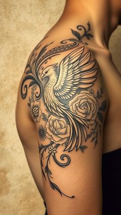 the back of a woman's shoulder with a bird and roses tattoo on it