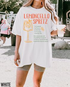 Cheers to la dolce vita with this retro-inspired tee! Featuring a Lemoncello Spritz recipe and a hand drawn graphic, this shirt captures the essence of Italian travel and timeless style. Perfect for those who dream of sunny days in Italy, sipping on a refreshing cocktail. We use professional quality DGT printing on all our apparel. Direct-to-garment, or DTG, is a high quality printing method that sprays ink directly onto the garment so there is no peeling or cracking. This fabulous graphic will be printed on a Comfort Colors Unisex T-Shirt. Please refer to the size charts in the images for the best fit.  Estimated Production Time: 1-5 days Estimated Shipping Time: 2-5 days 100% cotton shirt  Machine wash: cold  Non-chlorine: bleach as needed Tumble dry: low heat Iron, steam or dry: medium Summer Brunch T-shirt With Screen Print, White Graphic Print T-shirt For Brunch, Short Sleeve Screen Print Tops For Brunch, Spring Brunch Graphic Print T-shirt, Spring Brunch T-shirt With Short Sleeves, Spring Graphic Print T-shirt For Brunch, Retro White Print Short Sleeve T-shirt, Short Sleeve T-shirt With Screen Print For Brunch, Short Sleeve Screen Print T-shirt For Brunch