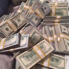 a pile of money sitting on top of a bed