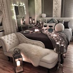 a white and black bedroom with candles on the bed