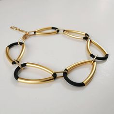 "A massive black and gold links statement necklace. Unique and sophisticated, this necklace will upgrade any elegant outfit. Share with the world your exquisite taste! Available in silver plating as well. * * * * * * * * * * * Materials: Gold plated brass - matte finish Silver plating - matte finish 0.20\"/5m\"m thick black silicon cord Measurements: Length: 19\"/48.5 c\"m + 2.75\"/7 c\"m extender Width:1.57\"/4 c\"m Thickness: 0.24\"/6 m\"m * * * * * * * * * * * For more jewelry from this colle Luxury Brass Statement Chain Necklace, Luxury Black Chunky Chain Necklace, Statement Jewelry Necklace, Necklace Chunky, Gold Statement Earrings, Gold Statement Necklace, Loop Earrings, Necklace Unique, Geometric Necklace