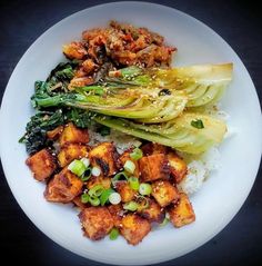 a white plate topped with tofu, cabbage and rice next to broccoli