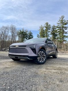 an electric car is parked in the gravel