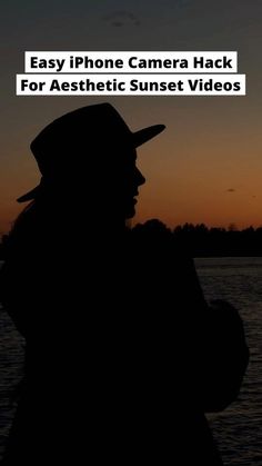 the silhouette of a man wearing a hat and holding a cell phone in his hand