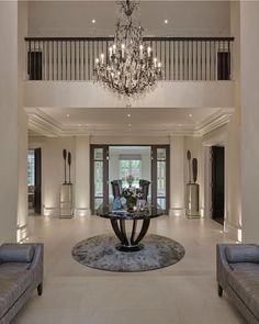 an elegant living room with chandelier and couches