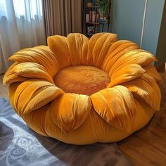 a large yellow flower shaped chair sitting on top of a wooden floor next to a window