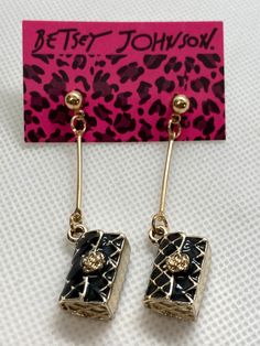 Betsey Johnson purse earrings Gold,black in color Actual size is 2 1/4" x3/4" inches I ship every day! Betsey Johnson, both the woman and the label, is constantly moving forward and continues to keep a strong foothold in the fashion industry with no signs of letting up anytime soon. Her love of detail and design is evident in everything she does in life and in business. Her enthusiasm, creativity and boundless talent that have kept her at the forefront of fashion for the past 45 years will keep Betsey going for years to come. I am a local distributor I have many of her pieces to choose from. Crescent City Ca, Betsey Johnson Christmas Jewelry, Betsey Johnson Earrings Betsey Johnson, Betsy Johnson Purses Handbags, Betsey Johnson Skull Bag, Betsey Johnson Purses, Betsey Johnson Necklace, Betsey Johnson Jewelry, The Fashion Industry