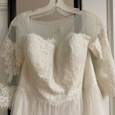 a white wedding dress hanging on a hanger