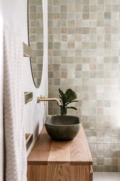 a bathroom sink sitting on top of a wooden counter next to a mirror and towel rack