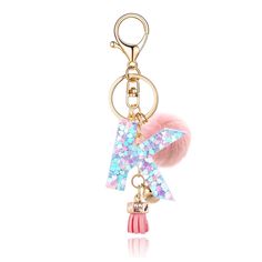 a key chain with a pink pom - pom on it and a letter charm hanging from the front