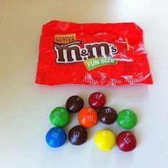 a bag of m & m's candy next to some candies