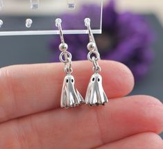 Cute and Dainty Ghost Earrings.  Introducing our stunning Sterling Silver Ghost Earrings! These hauntingly beautiful ghost earrings are the perfect blend of spooky and stylish.  Made from high-quality .925 sterling silver, these earrings are both durable and hypoallergenic, making them perfect for sensitive ears. Their unique silvery sheen adds a touch of elegance to any outfit, while the playful ghost shape adds a fun and quirky element.  Whether you're looking to make a statement on Halloween Gift Dangle Earrings, Gothic Sterling Silver Plug Earrings As Gift, Spooky Silver Pierced Earrings, Spooky Nickel-free Silver Earrings, Spooky Silver Nickel-free Earrings, Handmade Spooky Earrings For Gift, Halloween Dangle Pierced Earrings, Spooky Silver Earrings For Gift, Spooky Silver Dangle Earrings