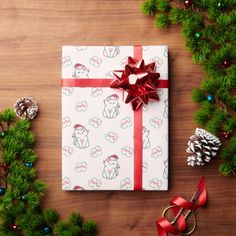 a present wrapped in pink paper and tied with red ribbon, surrounded by christmas decorations