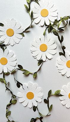 white flowers with yellow centers are arranged on a table