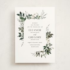 an elegant wedding card with greenery and white flowers