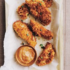 fried chicken sticks with dipping sauce on parchment paper