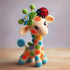 a crocheted giraffe with a ladybug on it's head