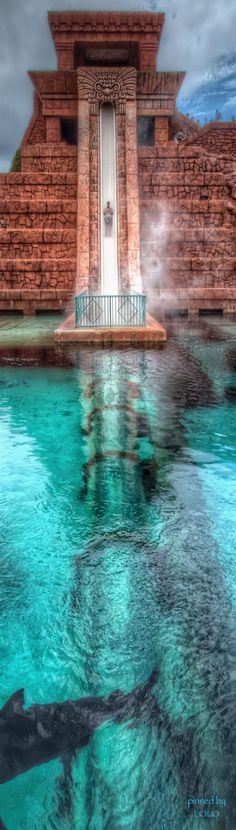 the water is crystal clear and blue in this pool with steps leading up to it