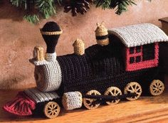 a crocheted toy train sitting on top of a wooden table