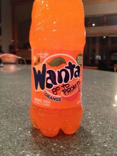 a bottle of orange soda sitting on top of a counter