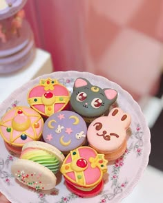 a person holding a plate full of decorated cookies and pastries in the shape of animals