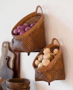 two baskets filled with mushrooms hanging on the wall