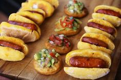 several hot dogs and pastries on a wooden board