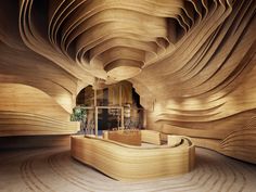 the interior of a building made out of wooden planks, with curved walls and flooring