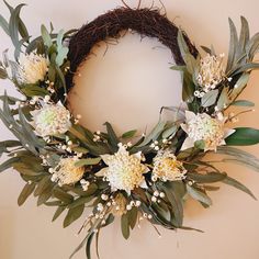 a wreath with white flowers and green leaves