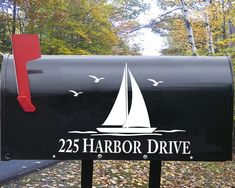 a black mailbox with a white sailboat on it and the words harbor drive