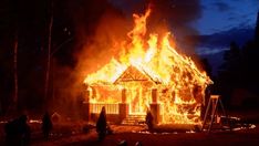 a house on fire with people around it