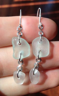 "These beautiful earrings are made from authentic seaglass combed from the beaches of northern California.  Light blue/green and white seaglass gems are laced together with intricate silver wire curls. Earwires and jumprings are made with silver-filled wire.  Each earring is approximately 1.5\" (not including the earwire length) and is a beautiful, nature-made accessory that is sure to dazzle onlookers!  Sea glass is glass from discarded bottles, lanterns, and other glasswork that has been tumbl Beach Earrings With Recycled Glass And Ear Wire, Beach Sea Glass Earrings With Ear Wire, Beach Earrings With Sea Glass And Ear Wire, Nickel-free Sea Glass Earrings For Jewelry Making, Handmade Sea Glass Dangle Earrings, Nickel-free Adjustable Sea Glass Earrings, Adjustable Nickel Free Sea Glass Earrings, Adjustable Nickel-free Sea Glass Earrings, Sea Glass Teardrop Earrings For Beach